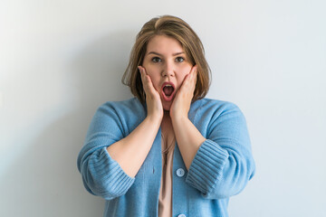 Plus size woman expression of surprise at white plain background. 