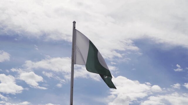 Pakistan national flag blowing in the wind isolated on high mountain hills. Official patriotic design. waving sign symbol.