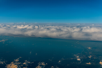 Fototapeta premium White clouds and blue sky. An aerial view of the Sweden from an airplane window.