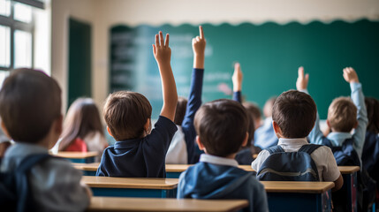 Enfants, élèves de primaire qui lèvent la main dans une salle de classe. Camarade de classe, écoliers en plein cours. Interroger, professeur, leçons. Rentrée scolaire, septembre. 