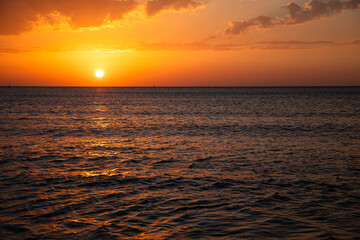 A Stunning Sunset Casting Vibrant Colors Over Serene Ocean Waves, Truly Breathtaking and Beautiful