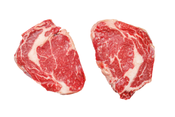 Raw ribeye steaks with savory spices