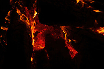 A roaring fire burns brightly in the dark, with dynamic orange and yellow flames that highlight the intense heat and captivating beauty of a blaze.