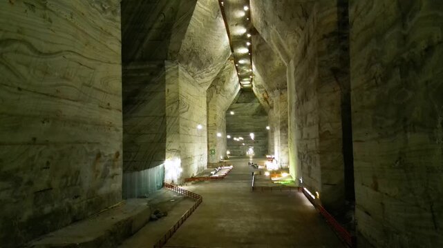 Aerial video inside a giant salt mine in the carpathian mountains of Romania. The vast mine of Salina Slanic Prahova seen from a drone. Flying within an old rock salt quarry. Tourist attraction.
