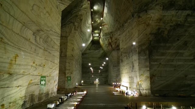 Aerial video inside a giant salt mine in the carpathian mountains of Romania. The vast mine of Salina Slanic Prahova seen from a drone. Flying within an old rock salt quarry. Tourist attraction.
