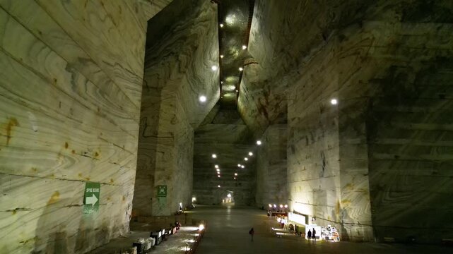 Aerial video inside a giant salt mine in the carpathian mountains of Romania. The vast mine of Salina Slanic Prahova seen from a drone. Flying within an old rock salt quarry. Tourist attraction.
