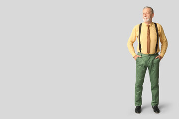 Fototapeta premium Handsome happy mature man with stylish tie on grey background