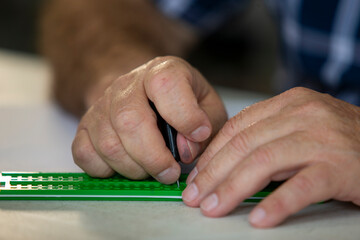 disabled person using a ruler to write in braille.Braille writing