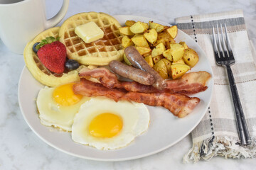 fried eggs with sausage , bacon and waffles