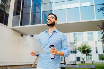 Fototapeta premium Young caucasian businessman going to work to modern business building