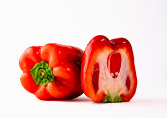 One whole and half bell pepper. Red, fresh, juicy, fleshy and crispy bell pepper. Close up on a white background.