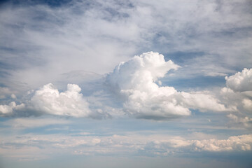 Cumulus clouds of an impressive shape in the blue sky in sunny weather.