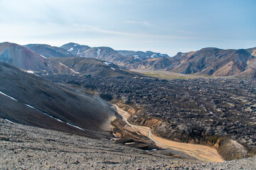 Hiking up the sulphur peak with views of old lava remains and river meandering through in Landmannalaugar in Iceland