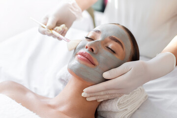Beautiful woman having facial cosmetic treatment from professional dermatologist at wellness spa....
