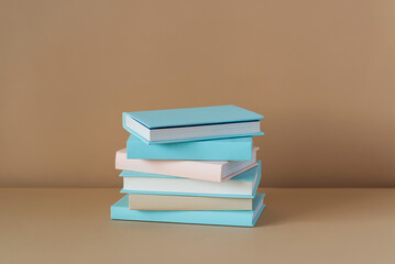 Stack of blue books on a brown background with soft shadow, copy space. Book Lovers Day concept