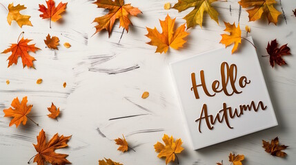Hello autumn text on a white board with leaves, set against a clean background, capturing the essence of fall and seasonal greetings