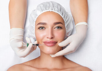 Lips injection concept. Woman receiving filler for lips contouring or augmentation, lying in...