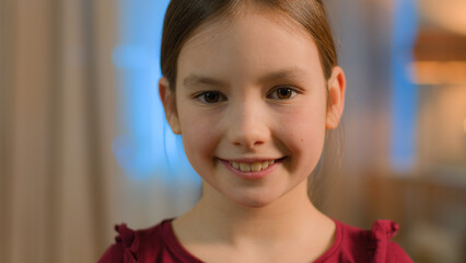 Close up portrait little Caucasian girl daughter child schoolgirl happy joyful toothy smiling...