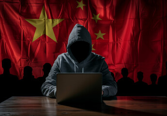 Anonymous identity hacker wearing hoodie using computer typing with chinese flag background cyber...