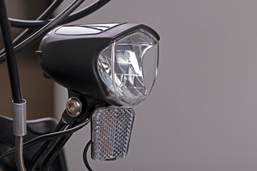 Plastic bicycle lamp in a black housing designed to illuminate the cyclist's path at night. © Piotr