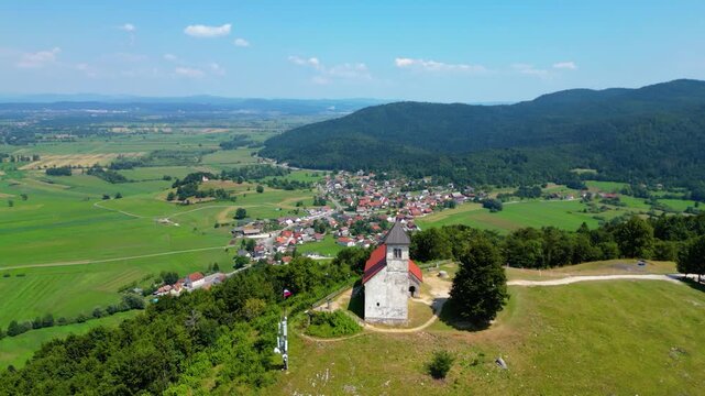 A stunning aerial view of Cerkev sv. Ane, Jezero, and Jezero pri Podpeči in Slovenia, captured by a drone. This captivating image showcases the picturesque church of St. Anne, serene lakes