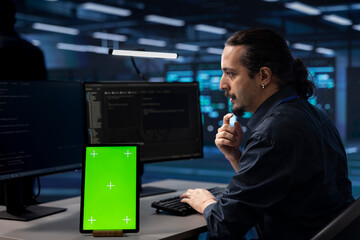 Technician using isolated screen screen tablet to check for signs of imminent failure in data...