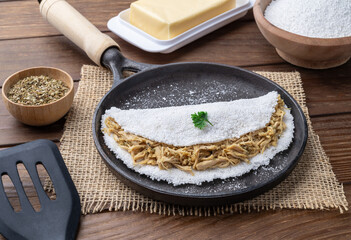 Traditional brazilian chicken stuffed tapioca on a pan with ingredients