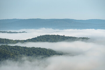 Stuning morning fog over mountain valley showing cloud covered mountain tops, summer background, natural authentic