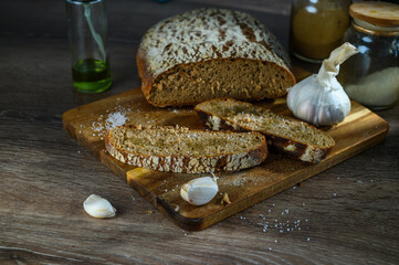 Loaf of sliced rye bread on an old board viewed low angle on a table with copy space