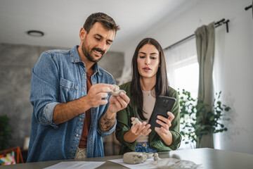 Couple learn from mobile phone how to make a clay figurine, pottery