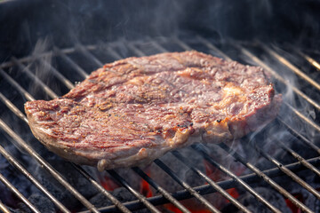 steak grilling on charcoal grill