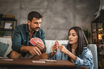 Couple boyfriend and girlfriend play card together at home