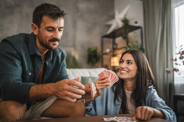 Girlfriend sit on the floor and hold card play with her boyfriend