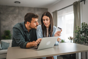 adult couple buy online on laptop with credit card at home