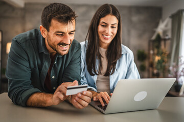 adult couple buy online on laptop with credit card at home