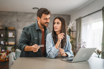 adult couple buy online on laptop with credit card at home