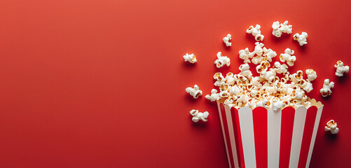 Flat lay composition with popcorn on red background, copy space