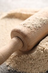Rolling pin and flour on table, closeup