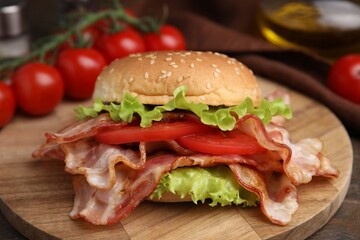 Delicious burger with bacon, tomato and lettuce on table
