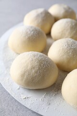 Raw dough balls on light grey table