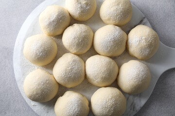 Raw dough balls on light grey table, top view