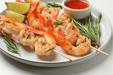 Skewers with delicious grilled shrimps served on white table, closeup