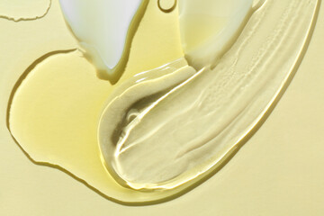 Smears of different cosmetic products on beige background, closeup