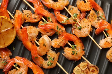 Skewers with delicious shrimps on grill pan, top view