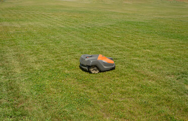 Green grass field beautifully fresh mowed lawn with the lines and lawn mowing machine