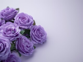 Fototapeta premium A bouquet of purple roses arranged on a white surface, perfect for wedding or romantic occasion decorations