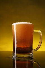 Glass of beer with froth on dark table, closeup