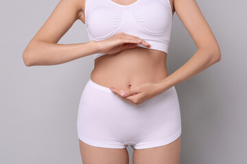 Diet and weight loss concept. Woman with slim body against light grey background, closeup