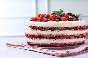 Tasty sponge cake with different fruits and mint on light grey table, closeup