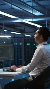 Vertical video Developer and coworker overseeing data center, making improvements and updates to ensure system can handle networking tasks. Teamworking colleagues in server room tracking network